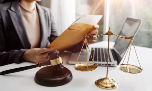 Business and lawyers discussing contract papers with brass scale on desk in office. Law, legal services, advice, justice and law concept picture with film grain effect